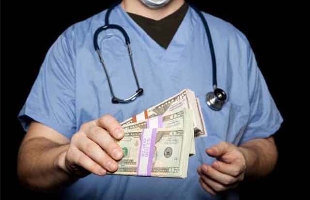 Pictured: a doctor holding cashing. One mistake businesses can make when they merge is neglecting to examine their existing vendor relationships, leading them to pay inconsistent pricing for the same office and medical supplies.